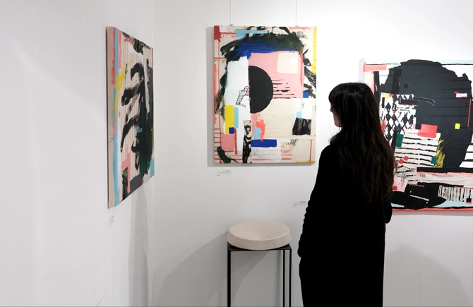 woman looking to paintings at apaixonarte gallery