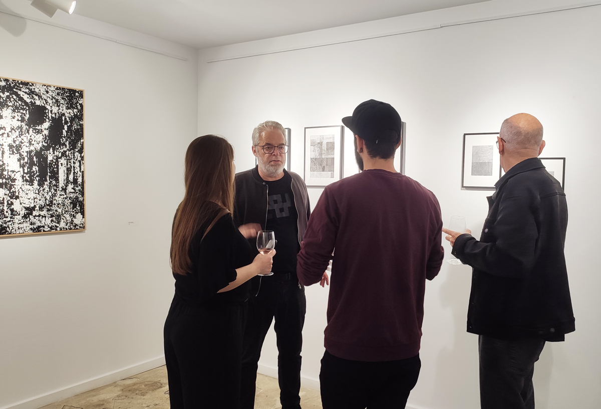 people looking an art show at apaixonarte gallery