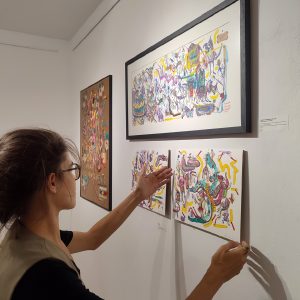 The artist Rita Ravasco with her artwork on Apaixonarte gallery